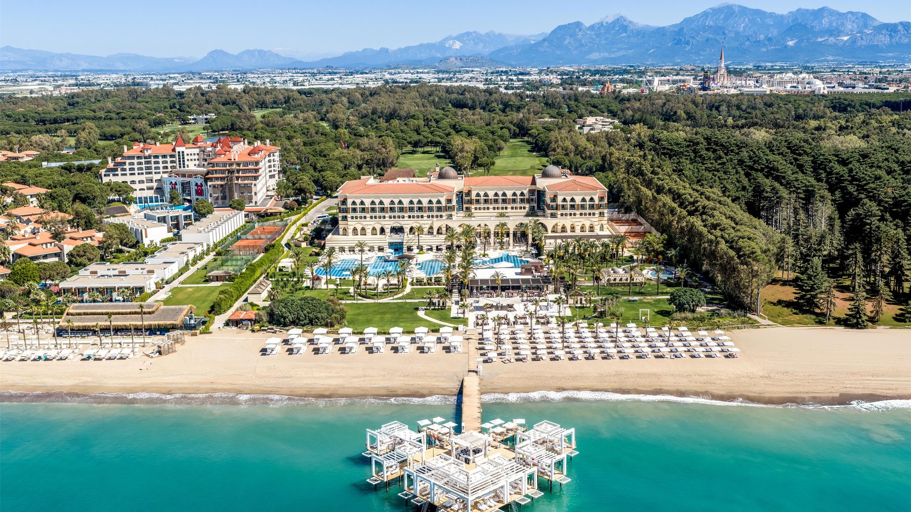 Пляж Белека и пирс Kempinski The Dome с высоты, за сосновым лесом — Таврские горы